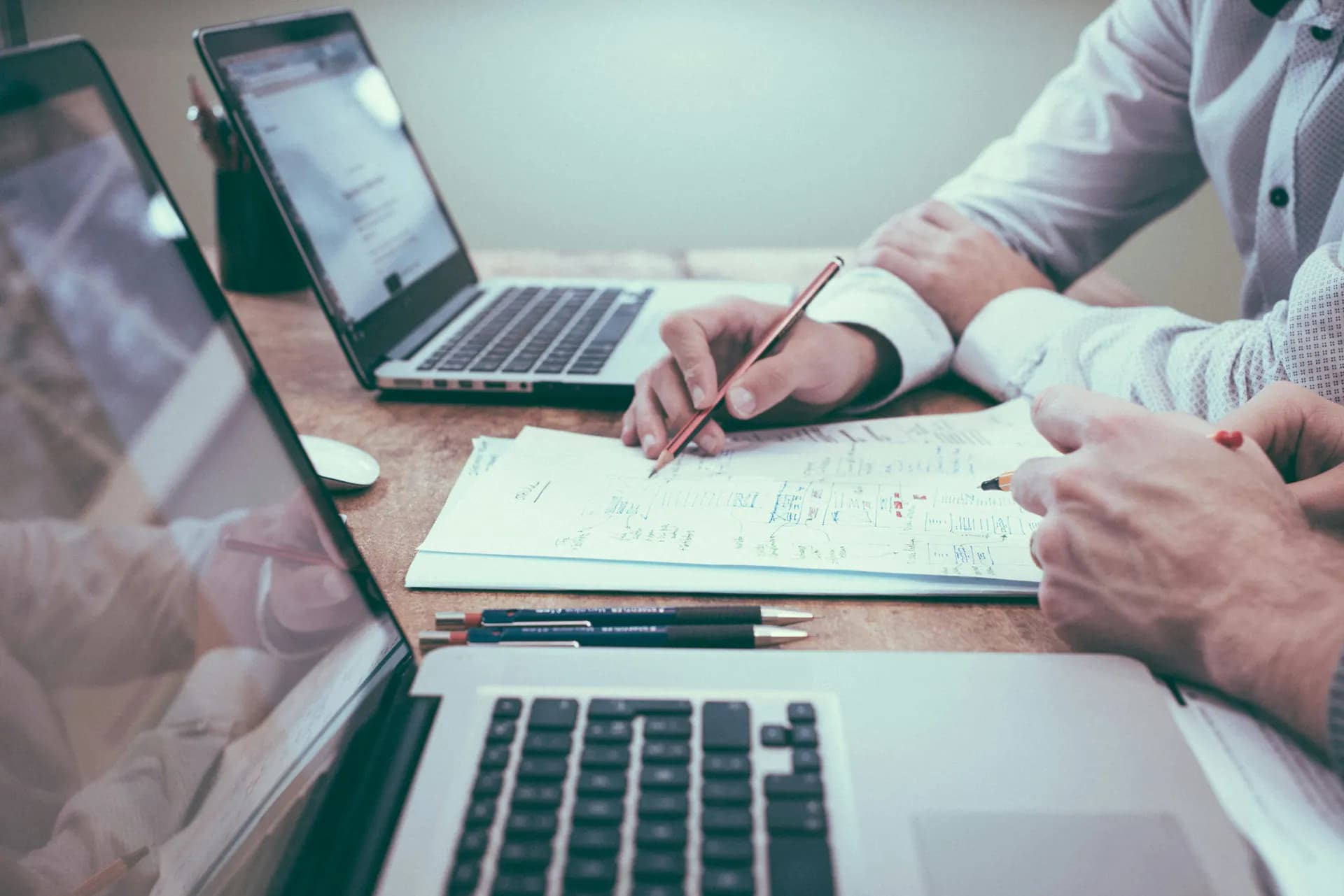 Dos personas trabajan sobre un esquema junto a sus portátiles